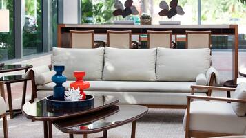 Una sala moderna con sofá, sillones, una mesa de centro y objetos decorativos.