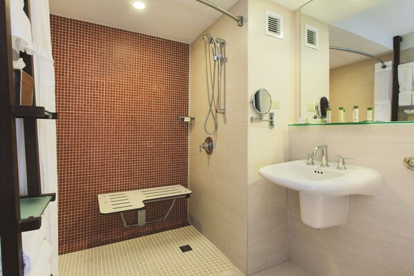A bathroom with a shower, a sink, and a mirror. - DoubleTree by Hilton San Juan (San Juan)