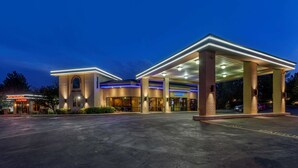 A hotel with a restaurant lounge, a lobby, and a parking area. - Best Western Dunmar Inn (Evanston)