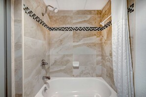 Bañera con ducha, toallas, jabón, papel higiénico