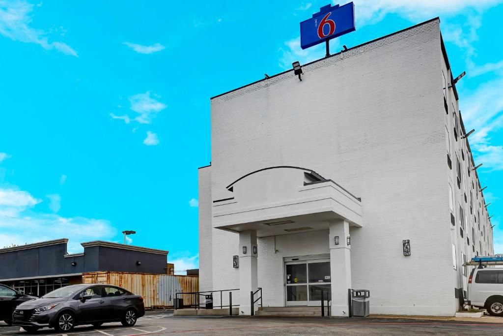 Un bâtiment blanc avec une enseigne bleue indiquant le numéro de la chambre : 6.