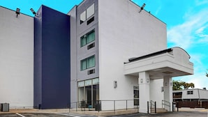 A modern building with a flat facade, large windows, and a covered entrance area.