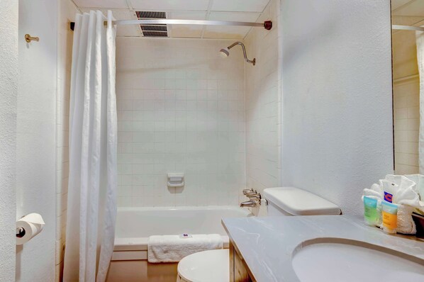 A bathroom with a bathtub, toilet, and sink.