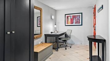 Una habitación con escritorio, silla y un espejo en la pared.