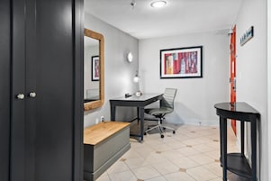 Una habitación con escritorio, silla y un espejo en la pared.