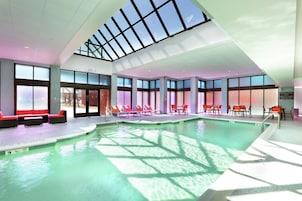 Una piscina techada, sillones reclinables de piscina