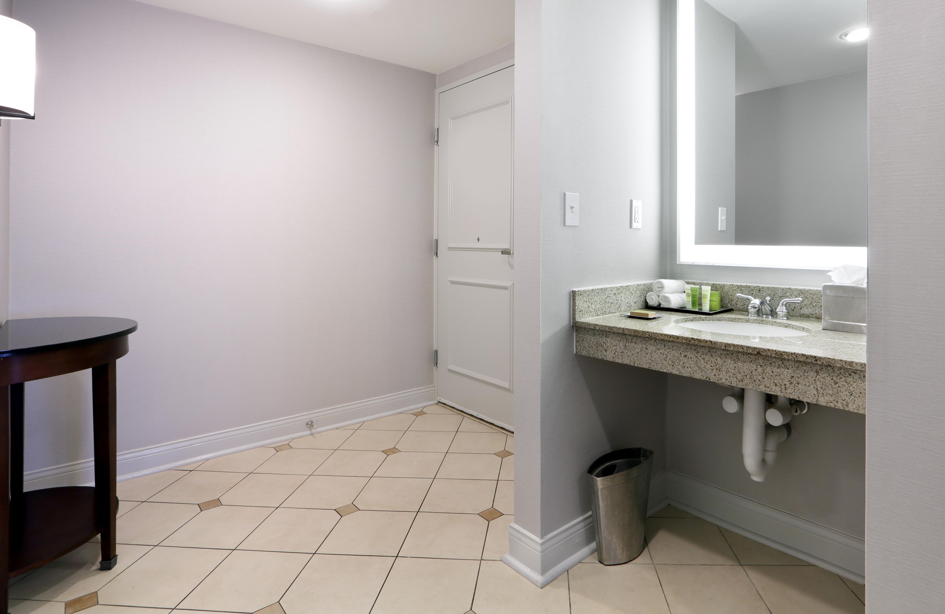 A bathroom with a sink, mirror, and toilet.