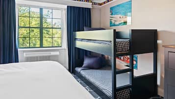 A room with a bunk bed, a window with curtains, a radiator, and a painting on the wall.
