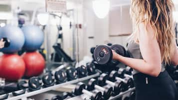 Un gimnasio con equipo de ejercicio, incluyendo pesas y pelotas de pilates.