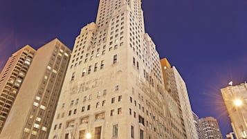 A high-rise building with multiple floors, large windows, and a prominent corner entrance.