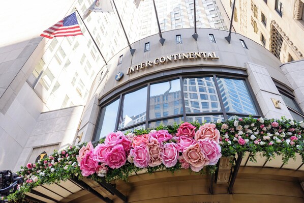 La façade de l’hôtel Intercontinental, ornée d’un grand drapeau américain et d’une composition florale.