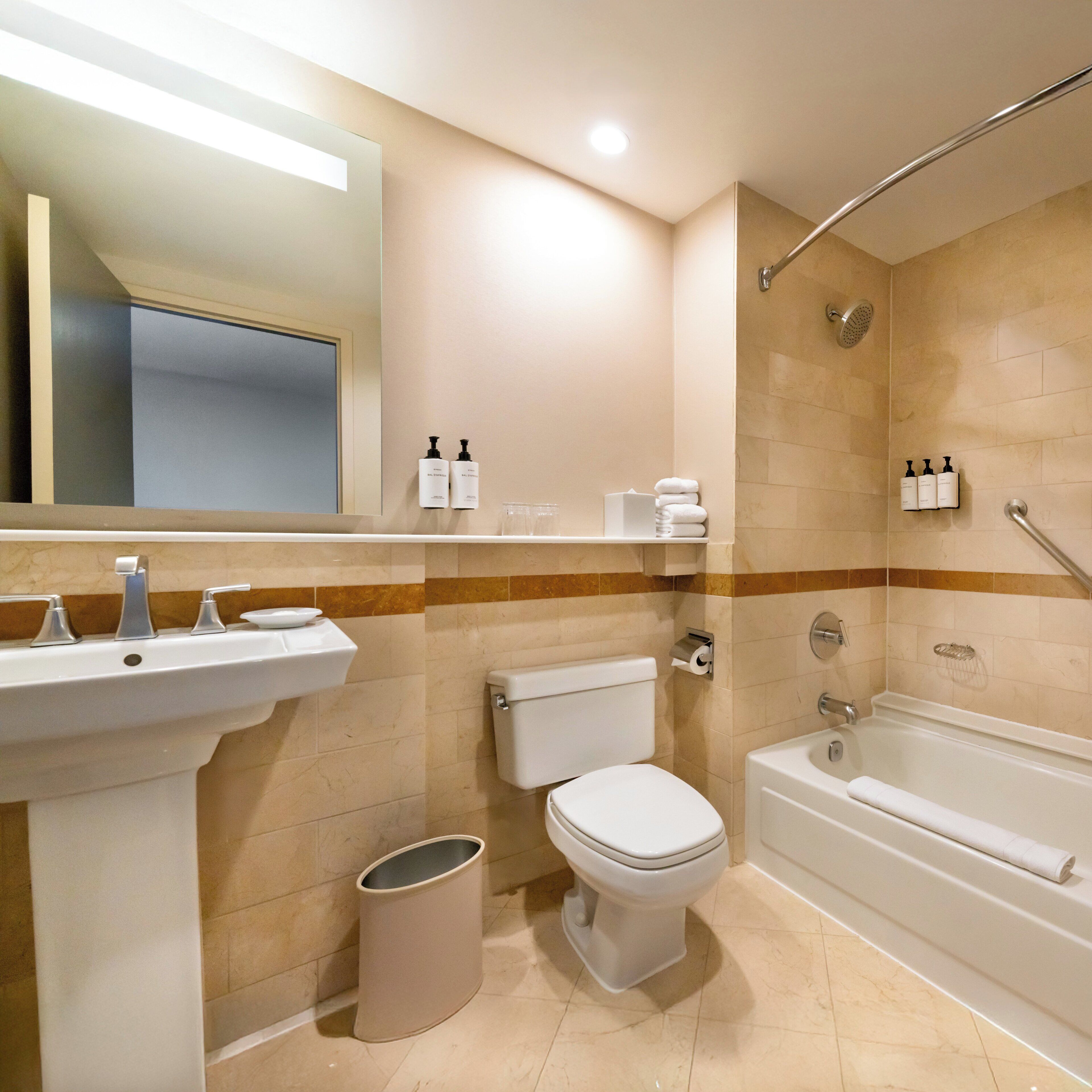 A modern bathroom with a sink, toilet, and bathtub.