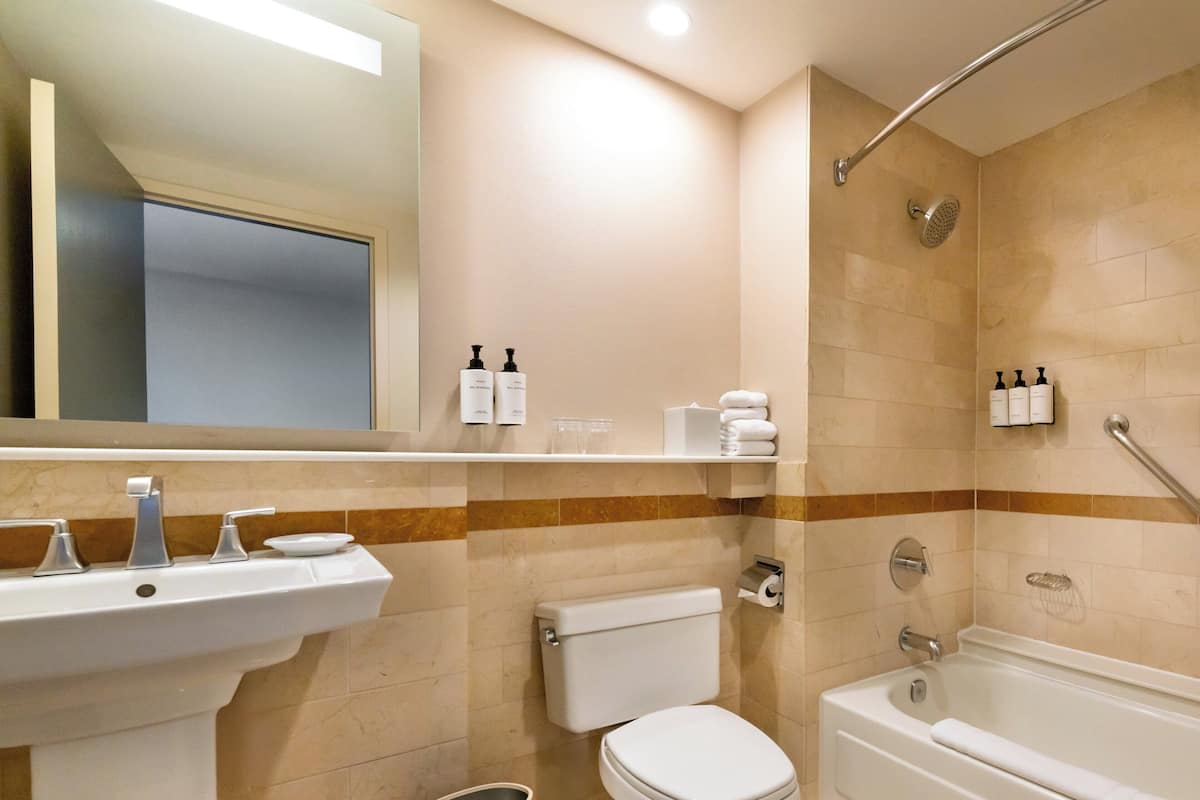Un baño moderno con lavamanos, inodoro y bañera.