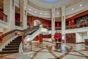 Stunning multi-level interior with a grand staircase, high ceilings, and a central column.