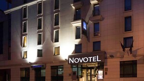 A hotel building with illuminated windows and a sign reading "NOVOTEL". - Novotel Paris Pont De Sevres (Sevres)