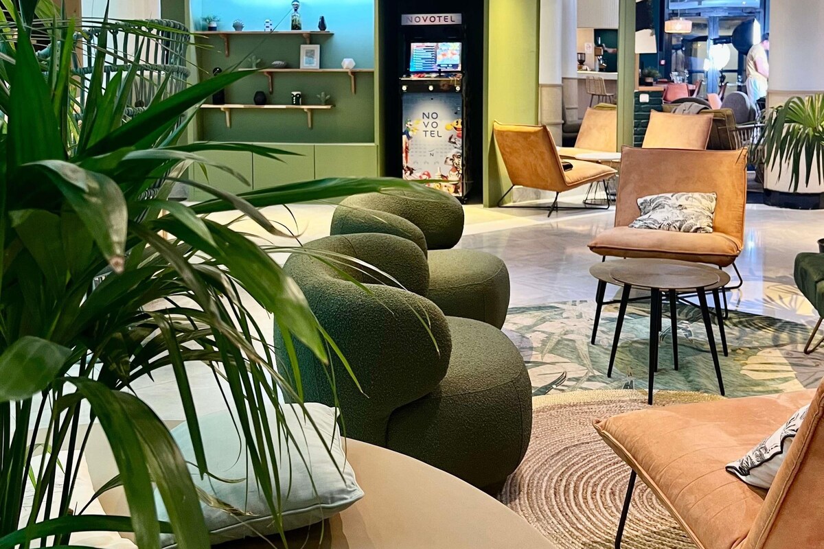 A hotel lobby with seating areas, a reception desk, and a minibar.