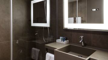 Une salle de bain moderne avec une douche à parois de verre, un meuble-lavabo et un grand miroir.