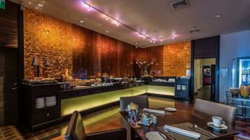 Un restaurant moderne doté d’un comptoir central, d’un espace salon et d’un mur décoratif.