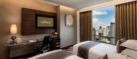 Une chambre d’hôtel avec deux lits, un bureau avec une chaise, un téléviseur fixé au mur et une grande fenêtre donnant sur la ville.