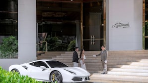 A white sports car parked in front of a building with a sign reading "The Landmark Bangkok." - The Landmark Bangkok (Bangkok)