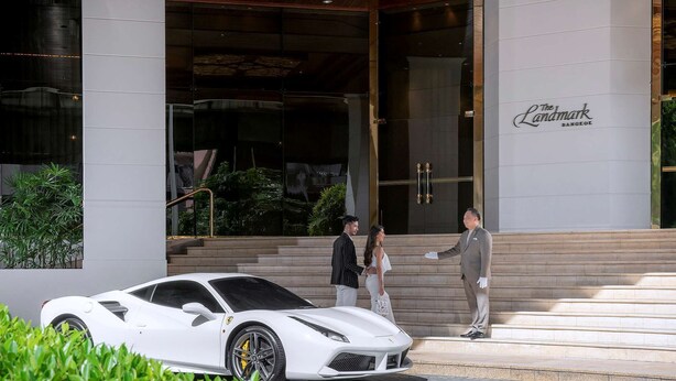 A white sports car parked in front of a building with a sign reading "The Landmark Bangkok." - The Landmark Bangkok (Bangkok)