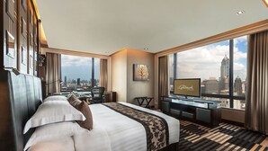 A hotel room with a large bed, a desk, a TV, and a city view. - The Landmark Bangkok (Bangkok)
