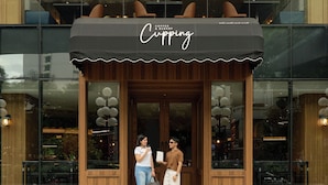 A coffee and bakery shop named 'Cupping' with a wooden facade and large windows. - The Landmark Bangkok (Bangkok)