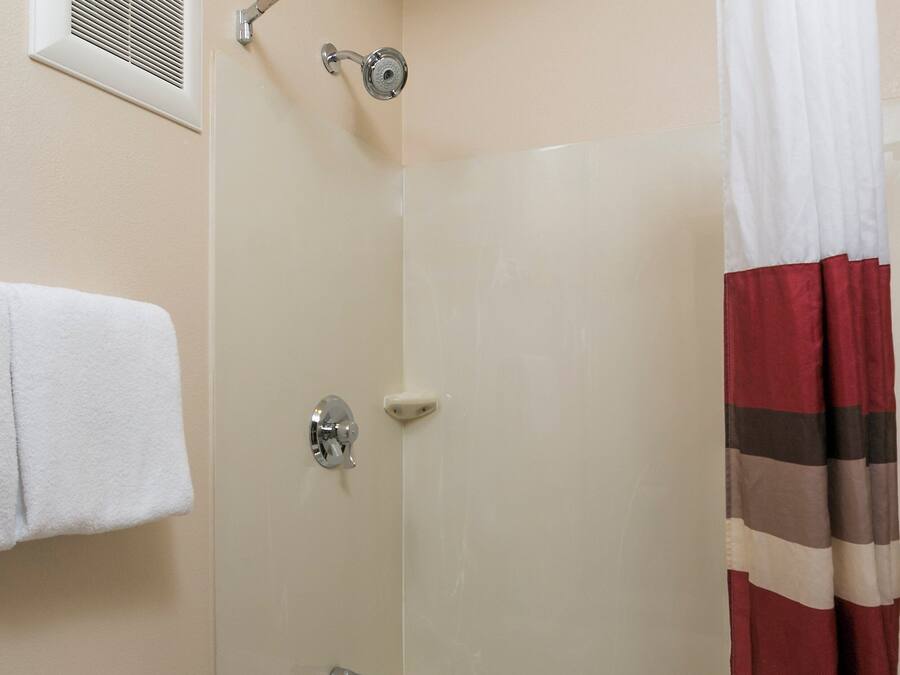 A bathroom with a bathtub, a shower curtain, and a towel rack.