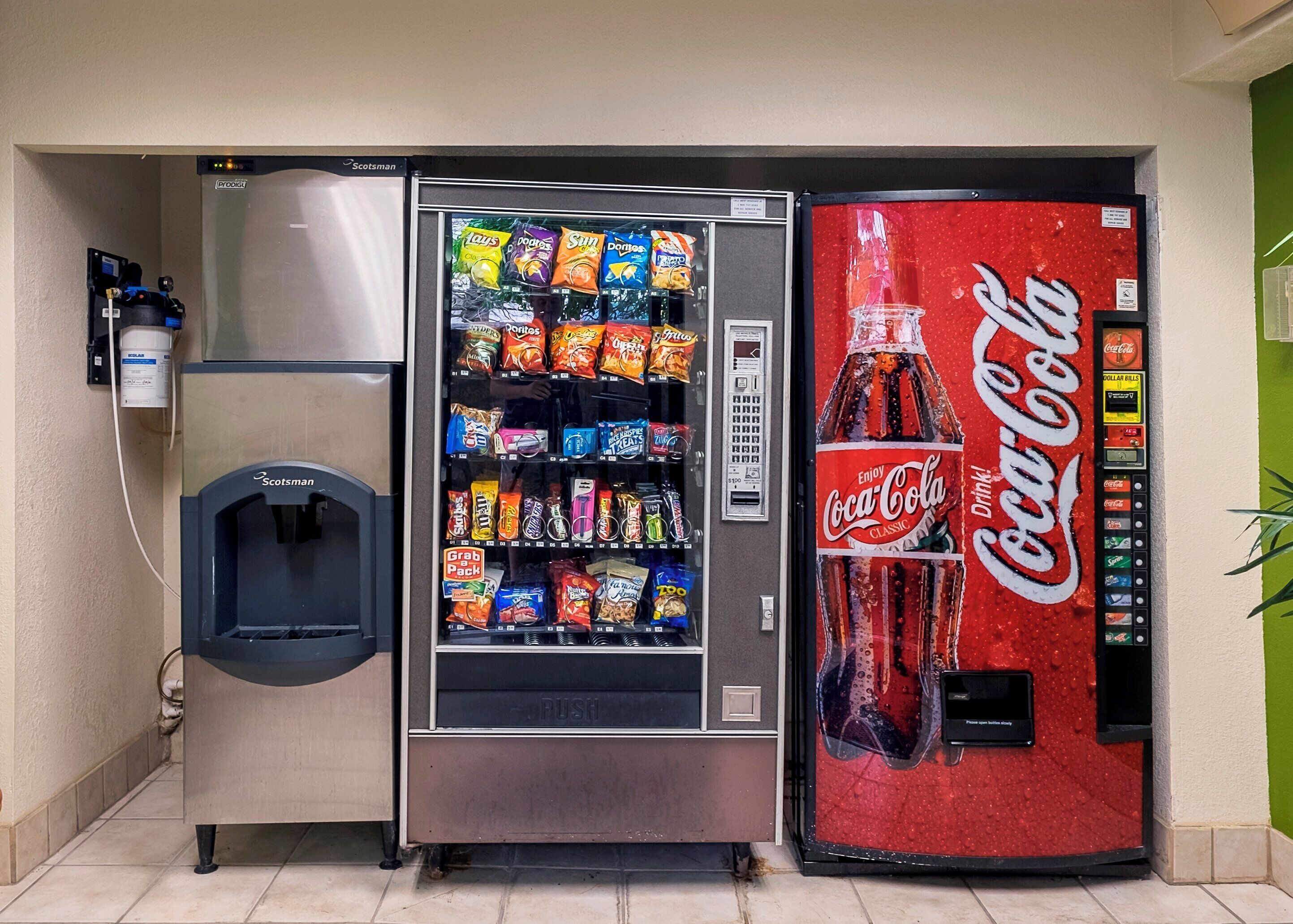 Máquina expendedora con dispensador de Coca-Cola y sección para paquetes de conveniencia.