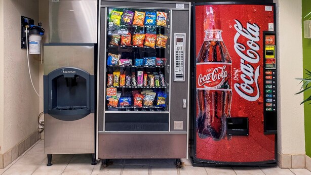 A vending machine with a Coca-Cola dispenser and a grab pack section. - Red Roof Inn Marietta (Marietta)