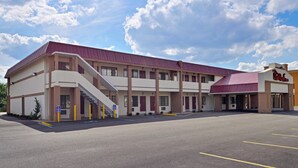 A Red Roof Inn with a two-story structure, a covered parking area, and a clear sky. - Red Roof Inn Marietta (Marietta)