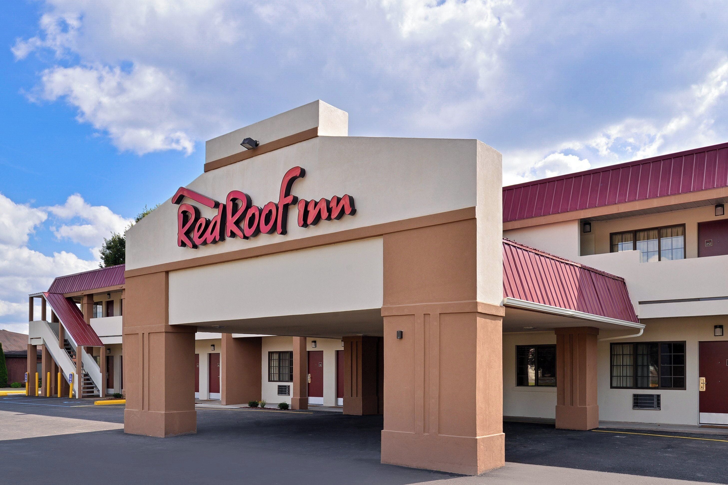Modernilla designilla varustettu Red Roof Inn -hotelli, jossa on näyttävä sisäänkäynti ja katettu pysäköintialue.