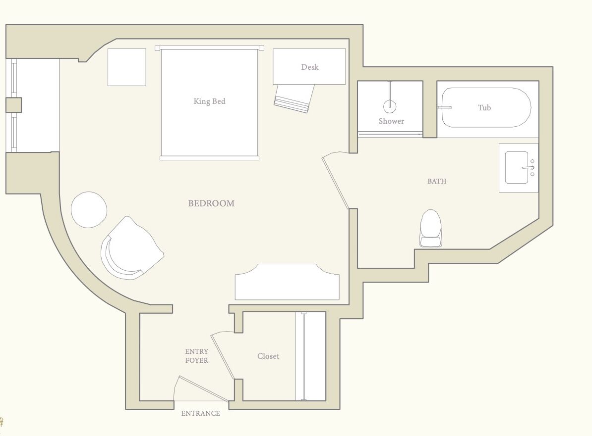 A bedroom with a king bed, a desk, a bathroom with a shower and tub, and an entry foyer leading to an entrance.