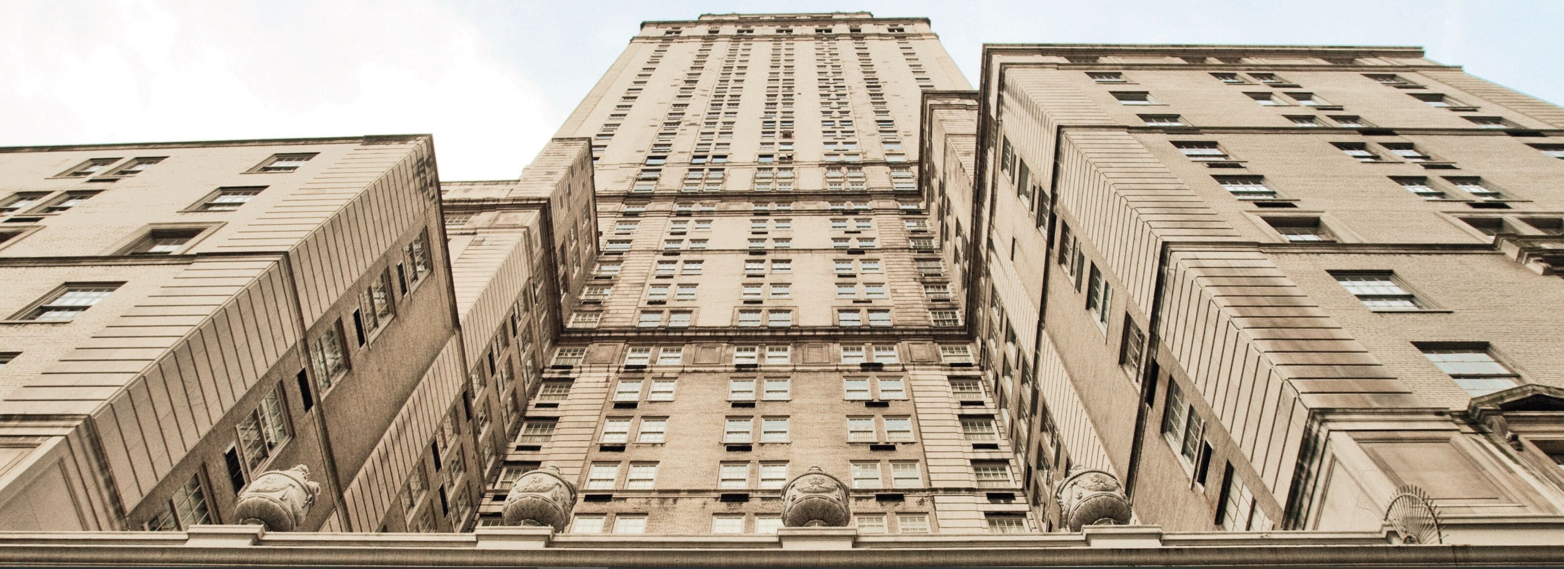 A tall, rectangular building with a symmetrical facade, featuring evenly spaced windows and decorative elements at the base.