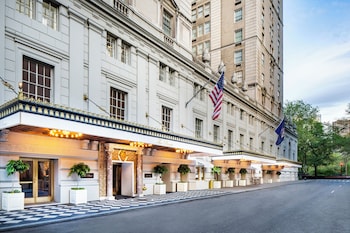 A lobby with a checkered floor, ornate columns, chandeliers, and a reception desk. at The Pierre, A Taj Hotel, New York