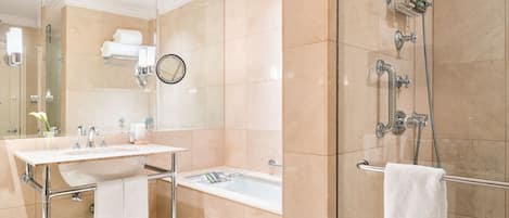 A modern bathroom with a glass-enclosed shower, a sink with a mirror, and a glass-topped vanity.