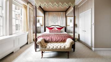 A four-poster canopy bed with a tufted headboard, a footboard, and a matching canopy.