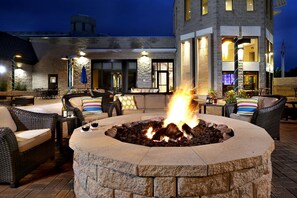 Relax by the fire pit surrounded by comfortable wicker furniture.
