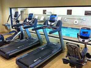 Stay active with our fitness area, featuring treadmills and a pool view.
