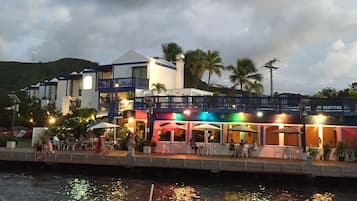 Un restaurant situé au bord de l’eau, doté d’une terrasse, d’un quai et d’un bateau.