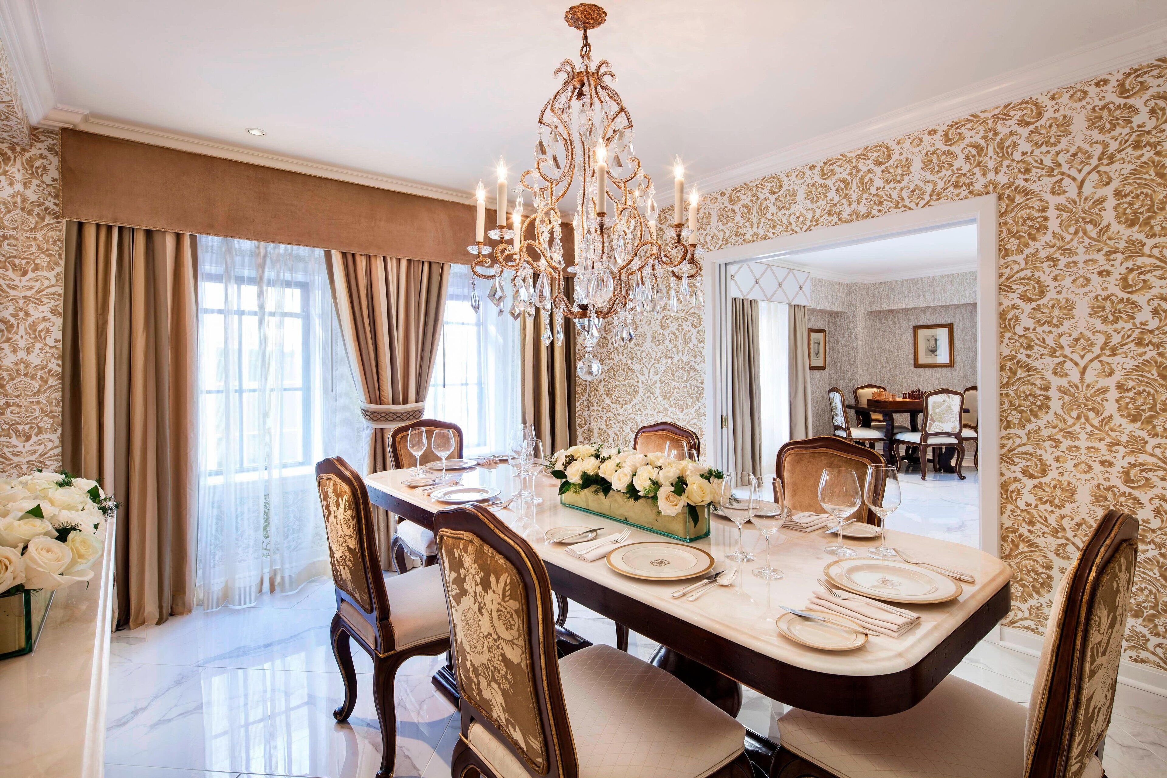 Un comedor con candelabro, un centro de mesa floral y una elegante vajilla.