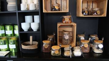 A kitchen area with shelves holding various kitchenware, including bowls, cups, and jars.
