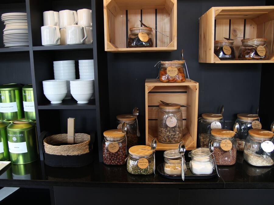 A kitchen area with shelves holding various kitchenware, including bowls, cups, and jars.