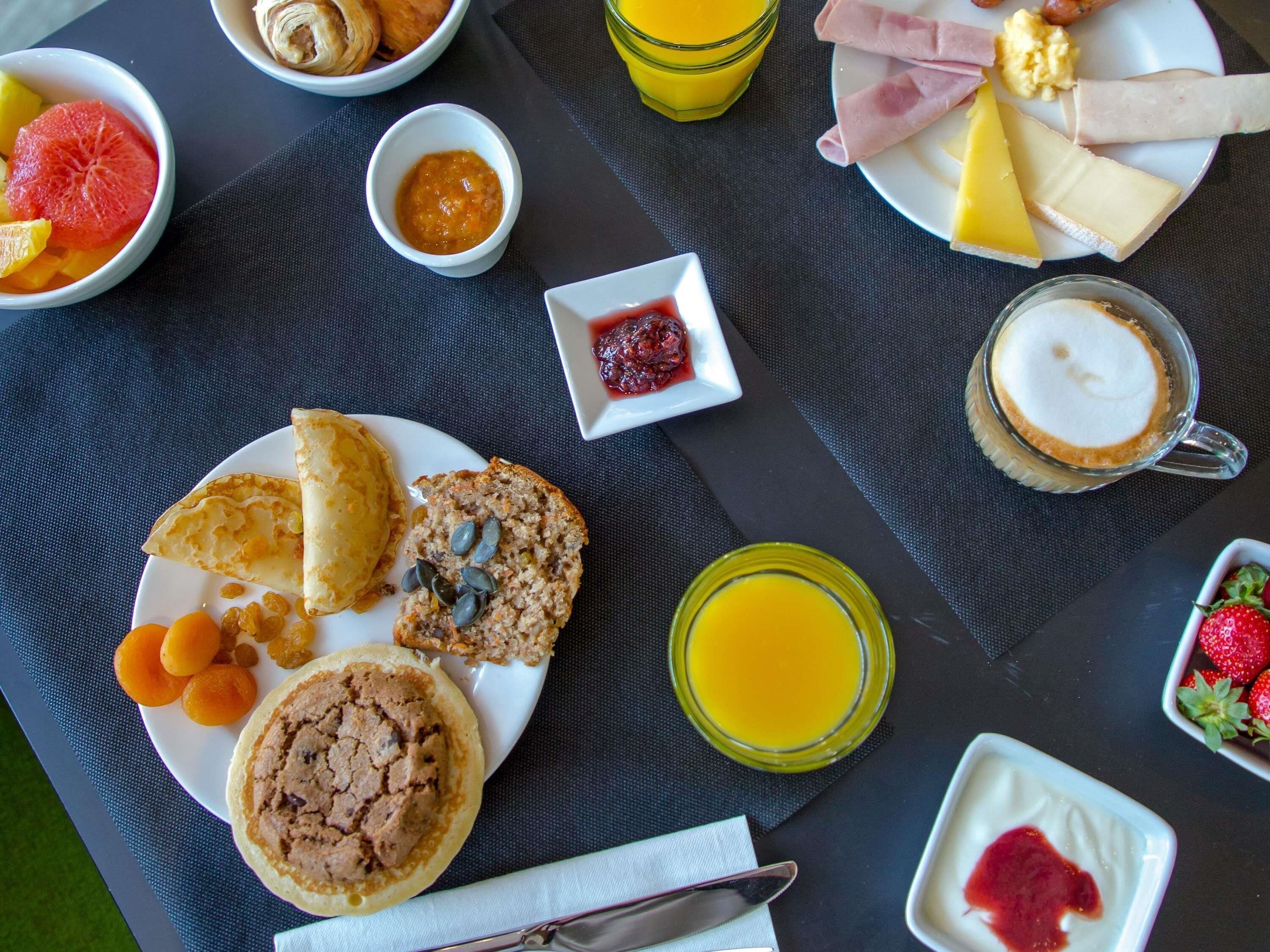 A breakfast setting with various food items and drinks on a table.
