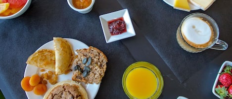 A breakfast setting with various food items and drinks on a table.