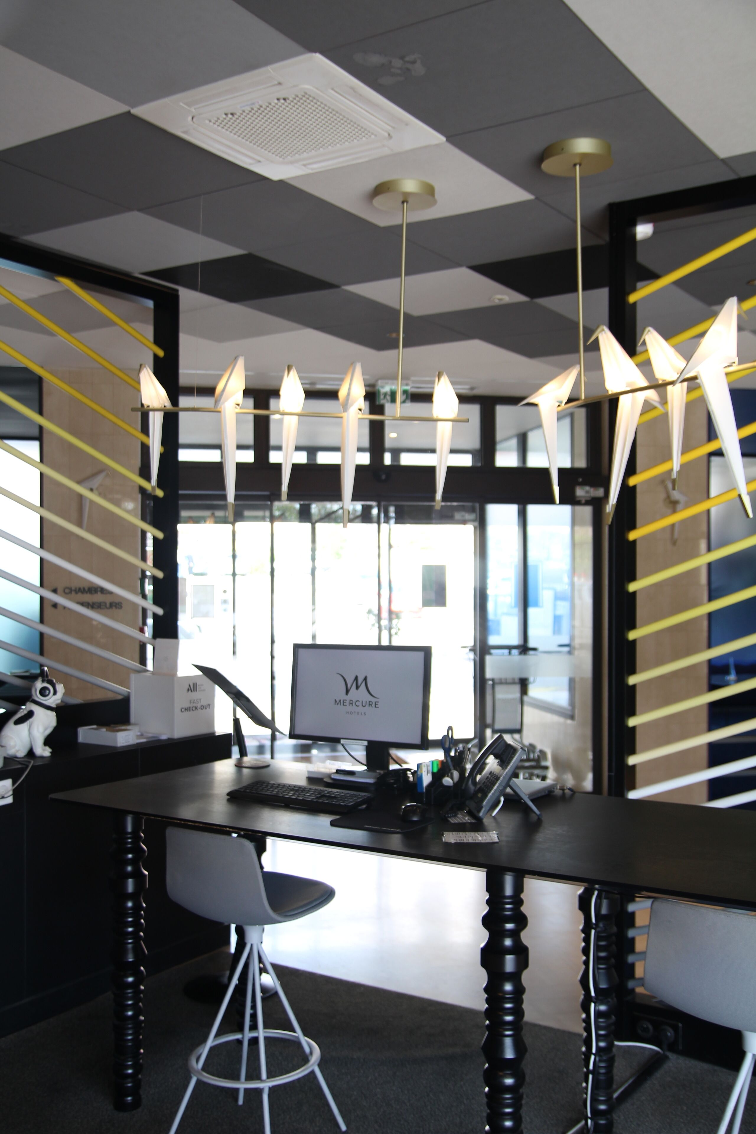 A modern office space with a check-out counter, a computer, and a chair.