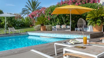 Een buitenzwembad en ligstoelen