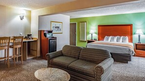 Une chambre d’hôtel avec un lit, un canapé, un bureau et une chaise.