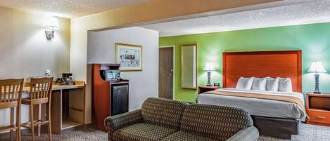 Ein Hotelzimmer mit einem Bett, einem Sofa, einem Schreibtisch und einem Sessel.