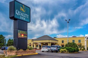 A Quality Inn hotel with a large sign, a covered parking area, and a building with a yellow facade. - Quality Inn Trinidad (Trinidad)